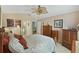 Main bedroom with a floral comforter, ceiling fan, and ample closet space at 24946 Cranes Roost Circle, Leesburg, FL 34748