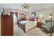 Main bedroom with a floral comforter, ceiling fan, and an armchair at 24946 Cranes Roost Circle, Leesburg, FL 34748
