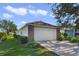 Single car garage with light beige door and brick facade at 24946 Cranes Roost Circle, Leesburg, FL 34748