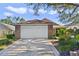 Two-car garage with light beige door and brick facade at 24946 Cranes Roost Circle, Leesburg, FL 34748