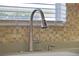 Stainless steel kitchen sink and faucet with tile backsplash at 24946 Cranes Roost Circle, Leesburg, FL 34748