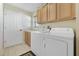 Laundry room with washer, dryer, cabinets, and a utility sink at 24946 Cranes Roost Circle, Leesburg, FL 34748