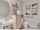 Accessible bathroom with toilet, sink, grab bar, and decorative wall art at 3234 Belize Pl, Haines City, FL 33844