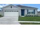 One-story home with white garage door and blue shutters at 3234 Belize Pl, Haines City, FL 33844