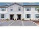 Two-story townhome with light gray siding and blue shutters, two-car parking at 7424 Oakmoss Loop, Davenport, FL 33837