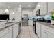 Modern kitchen featuring white cabinets, granite counters, and stainless steel appliances at 7424 Oakmoss Loop, Davenport, FL 33837