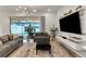 Living room with gray sofas, large TV, and view of private pool at 7424 Oakmoss Loop, Davenport, FL 33837
