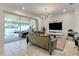 Open living area with gray sofa, sliding glass doors leading to pool at 7424 Oakmoss Loop, Davenport, FL 33837