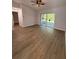 Living room with wood-look floors, sliding glass doors, and a ceiling fan at 911 Pine Ave, Mount Dora, FL 32757