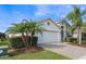 A one-story house with a white exterior, palm trees, and a brick driveway at 1012 Sadie Ridge Rd, Clermont, FL 34715
