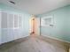 Bedroom with mirrored wall, carpet, and white closet doors at 117 Red Rose Cir, Orlando, FL 32835