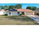 Tan one-story house with solar panels, attached garage, and landscaped yard at 117 Red Rose Cir, Orlando, FL 32835