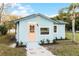 Charming light blue house with a peach door, well-manicured lawn, and walkway at 1309 E Parker St, Lakeland, FL 33801