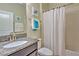 Clean bathroom with shower/tub combo, granite vanity, and white shower curtain at 1636 Moon Valley Dr, Davenport, FL 33896