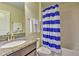 Bathroom with blue and white striped shower curtain and granite vanity at 1636 Moon Valley Dr, Davenport, FL 33896