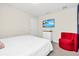 Bedroom with a queen bed, a red accent chair, and a large TV at 1804 Gobi Dr, Kissimmee, FL 34747
