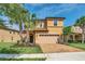 Two-story house with tan exterior, paver driveway, and landscaping at 1804 Gobi Dr, Kissimmee, FL 34747