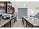 Modern kitchen with dark cabinets, granite counters, and stainless steel appliances at 1804 Gobi Dr, Kissimmee, FL 34747