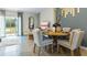 Bright dining area with wooden table and chairs, adjacent to a living room at 2389 Penguin Blvd, Davenport, FL 33837