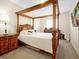 Main bedroom with a wooden canopy bed and ensuite bathroom at 2766 White Isle Ln, Orlando, FL 32825