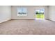 Living room with sliding glass doors, window and neutral carpet at 418 Caraway Dr, Kissimmee, FL 34759