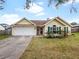 Charming yellow house with a white garage door and well-manicured lawn at 1071 Piedmont Lakes Blvd, Apopka, FL 32703