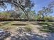 Large backyard with mature trees and a partially fenced area at 1215 Timberidge Dr, Lakeland, FL 33809