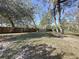 Spacious backyard with mature trees and a wooden fence at 1215 Timberidge Dr, Lakeland, FL 33809