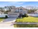 Two-story house with gray exterior, two-car garage, and green lawn at 488 Acacia Tree Way, Kissimmee, FL 34758