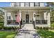 Front porch with black railings, American flag, and potted plants at 5910 Caymus Loop, Windermere, FL 34786