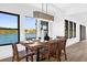 Modern dining room with a wooden table, leather chairs, and large windows overlooking a lake at 815 S Lake Formosa Dr, Orlando, FL 32803