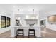 Kitchen island with seating, white cabinets, and modern lighting at 815 S Lake Formosa Dr, Orlando, FL 32803