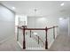 Upstairs hall with wood and white railings and carpet flooring at 12706 Bideford Ave, Windermere, FL 34786