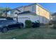 Two-story house with a black car parked in the driveway, and green recycling bins at 14112 Morning Frost Dr, Orlando, FL 32828