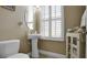Small bathroom with pedestal sink and window at 607 Pensacola Ln, Lake Mary, FL 32746