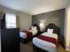 Bright bedroom with two twin beds, nightstands, and a dresser at 6165 Carrier Dr # 2401, Orlando, FL 32819