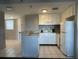 Small kitchen with white cabinets and appliances at 6165 Carrier Dr # 2401, Orlando, FL 32819