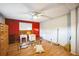 Bedroom with wood floors, ceiling fan, and red accent wall at 6522 Glen Meadow Loop, Lakeland, FL 33810