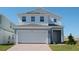 Two-story house with gray siding, white trim, and a two-car garage at 6805 Serpent Hawk Lane St, Howey In The Hills, FL 34737