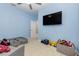 Light blue bedroom with a twin bed and large TV at 1380 Clear Brook Pl, St Cloud, FL 34772