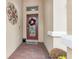 Front entry with red door, wreath, and brick flooring at 1380 Clear Brook Pl, St Cloud, FL 34772