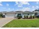 Single-story home with light blue exterior, attached garage, and well-maintained lawn at 1409 Lake Marion Dr, Apopka, FL 32712