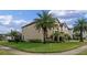 Tan two-story house with palm trees and a landscaped yard at 1827 Pisgah Ln, Apopka, FL 32712