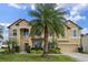 Two-story house with tan exterior, palm trees, and a three-car garage at 1827 Pisgah Ln, Apopka, FL 32712
