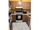 Bright kitchen features brown cabinets, white appliances, and tile flooring at 262 Scottsdale Sq # 262, Winter Park, FL 32792