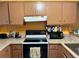 Bright kitchen features brown cabinets, white appliances, and tile flooring at 262 Scottsdale Sq # 262, Winter Park, FL 32792