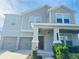 Two-story house with gray siding, stone accents, and a two-car garage at 10118 Storey Grove Way, Winter Garden, FL 34787