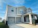 Two-story house with gray siding, stone accents, and a two-car garage at 10118 Storey Grove Way, Winter Garden, FL 34787