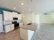 Open kitchen with island, stainless steel appliances, and teal accent wall at 10118 Storey Grove Way, Winter Garden, FL 34787