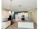 Modern kitchen with white cabinets, island, and teal accent wall at 10118 Storey Grove Way, Winter Garden, FL 34787